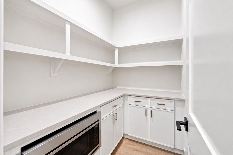 Walk-in pantry with microwave drawer.
