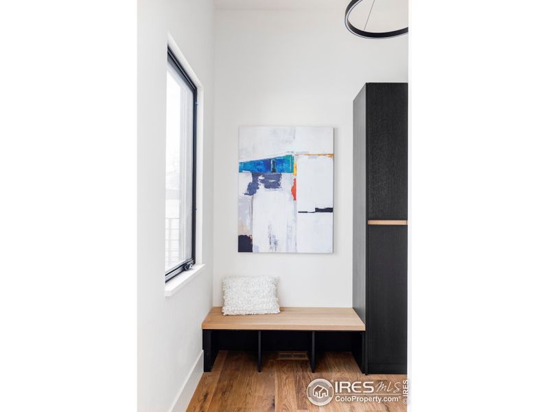 The entryway to the residence features a bench with coat closet and storage cabinets.