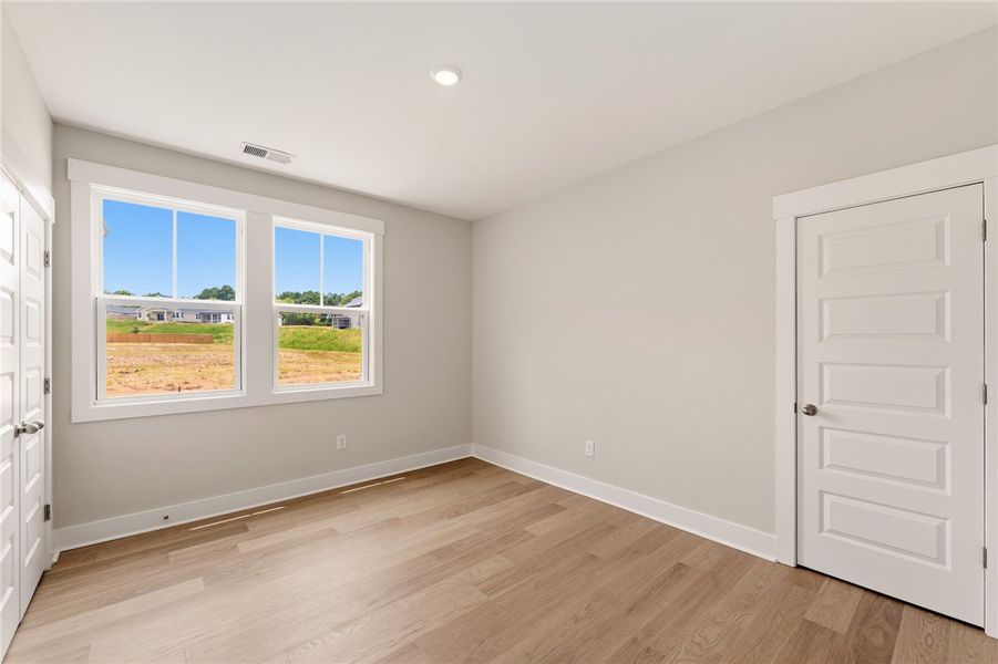 A versatile room features light-toned wood floorin
