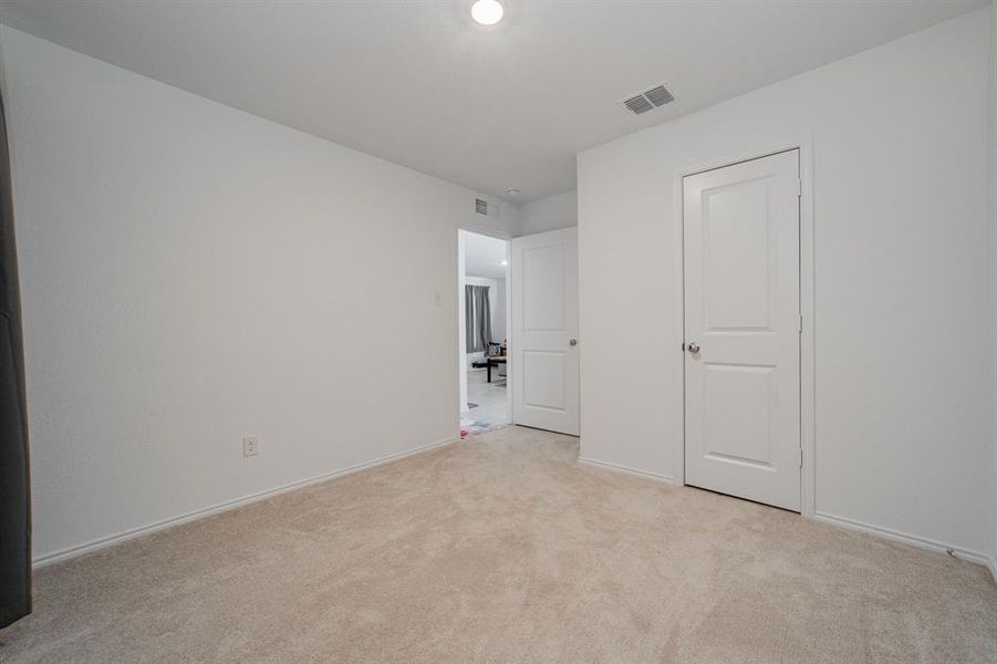 Unfurnished bedroom featuring light colored carpet and baseboards