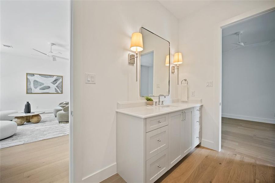 Bathroom with vanity, wood finished floors, and a ceiling fan