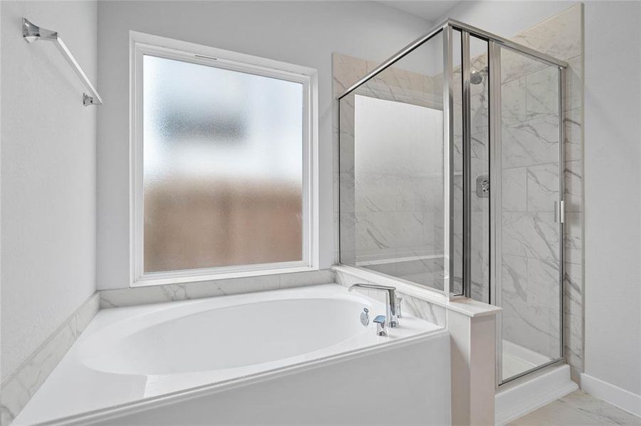 Additional view of the primary bathroom featuring a framed walk-in shower with tile surround, separate garden tub for soaking after a long day!