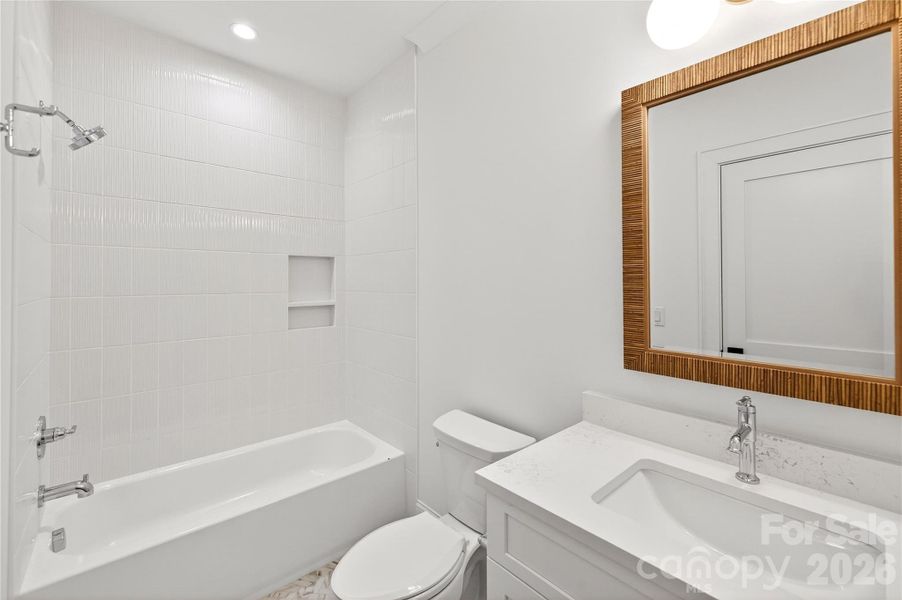 3rd Bedroom In-suite Bathroom. Rectangular mirror. Bathtub / shower.