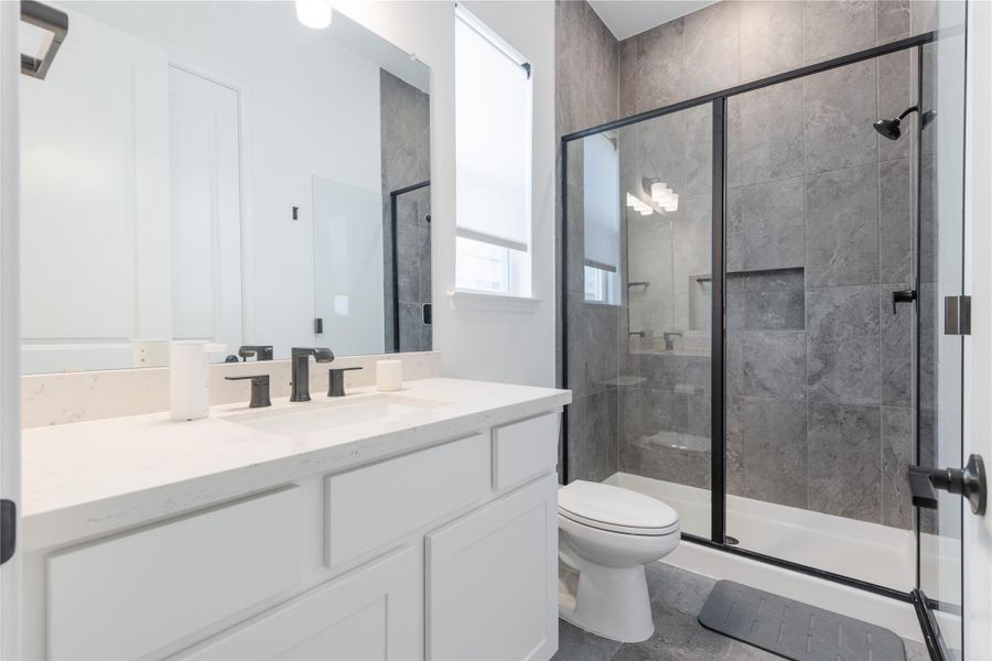 Bathroom featuring a shower stall and vanity