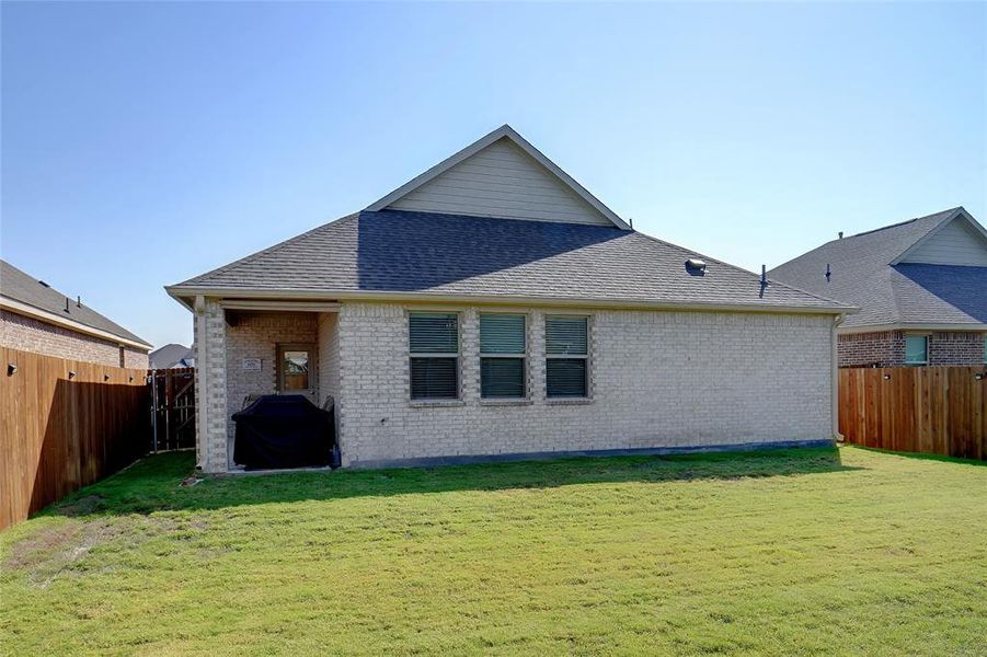 Rear view of property with a yard