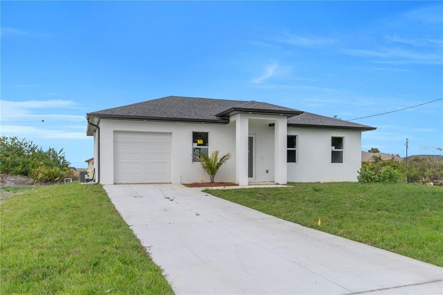 Front exterior of a new home in , Lehigh Acres, FL, highlighting curb appeal (Image 22).