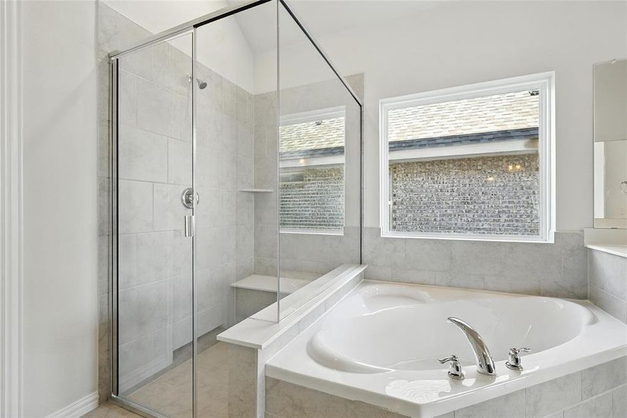 Bathroom featuring a bath and a stall shower Bathroom featuring a bath and a stall shower