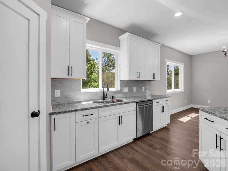 Custom shelving in walk-in pantry to the left, granite cabinets and hardwood floors, oversized farm sink, open floorplan Custom shelving in walk-in pantry to the left, granite cabinets and hardwood floors, oversized farm sink, open floorplan