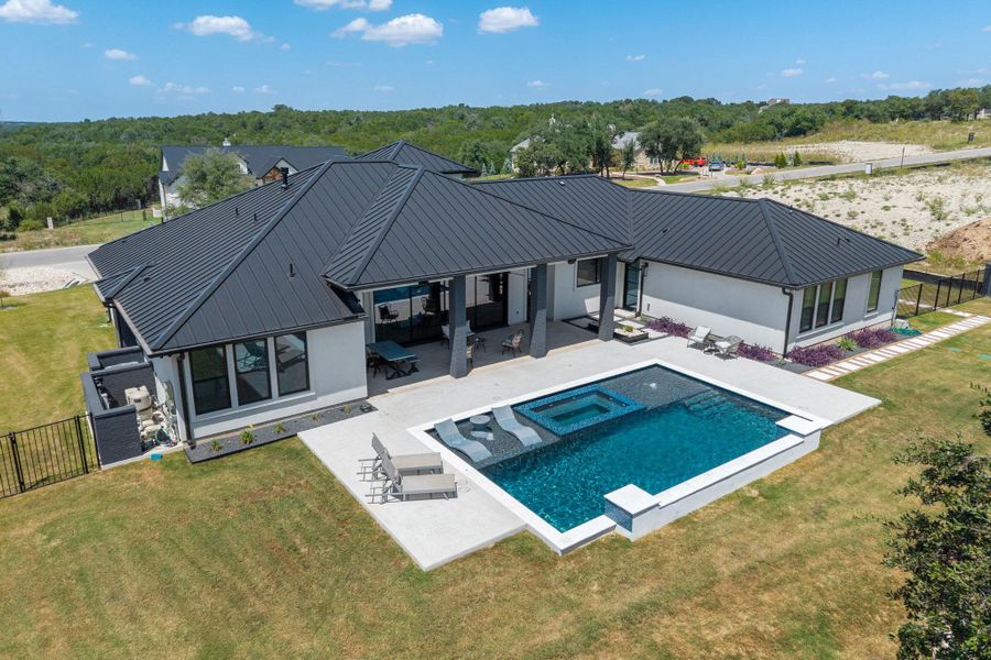 An inviting backyard oasis features a modern swimming pool against a dark metal roofline.