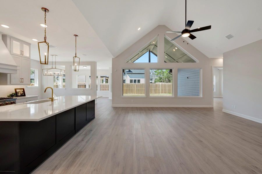 EXAMPLE PHOTO:  Large Living area that is open to Kitchen, Dining & Sunroom that is complimented by cathedral cewiling and trapezoid windows above big picture windows.
