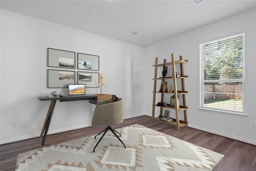 Quietly nestled in the back of the the home is the handsome den used here as a home office. Featuring vinyl plank flooring, custom paint and large window with privacy blinds.