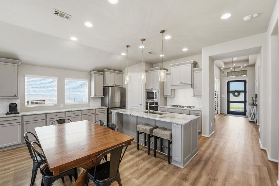 Open plan kitchen with breakfast island, overlooking dining area and family room