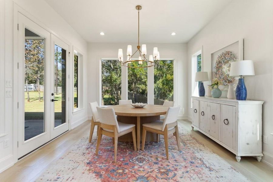Dining space with light wood-type flooring, a chandelier, and recessed lighting