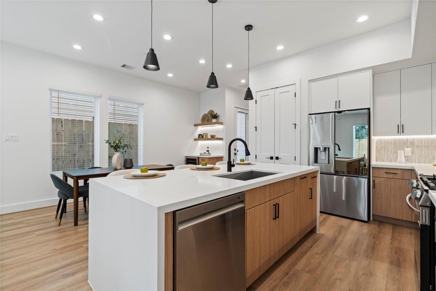 Sleek recessed lighting and modern black finishes, complemented by striking pendant lights, bring a contemporary edge and warm ambiance to the home’s stylish interior. Sleek recessed lighting and modern black finishes, complemented by striking pendant lights, bring a contemporary edge and warm ambiance to the home’s stylish interior.