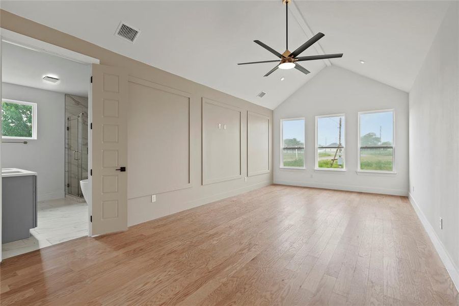 Unfurnished living room featuring ceiling fan, lofted ceiling, and light wood finished floors Unfurnished living room featuring ceiling fan, lofted ceiling, and light wood finished floors