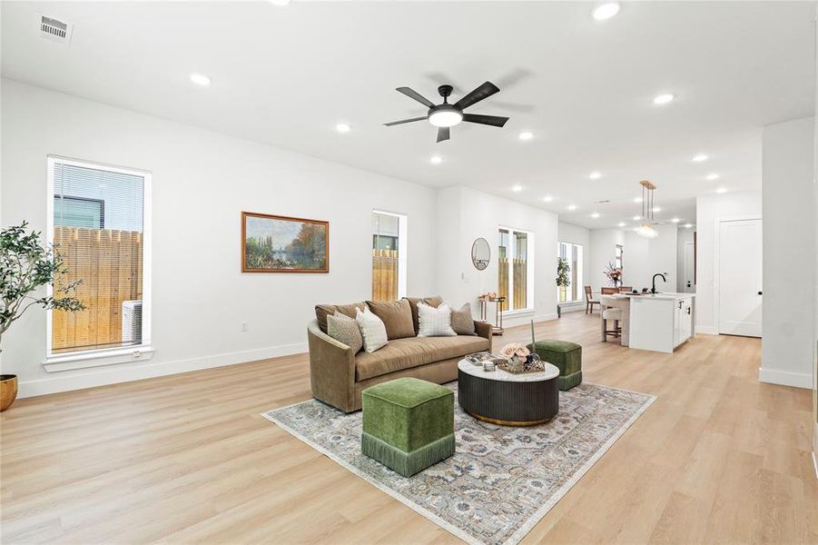 Living room featuring recessed lighting, light wood-type flooring, and a ceiling fan Living room featuring recessed lighting, light wood-type flooring, and a ceiling fan