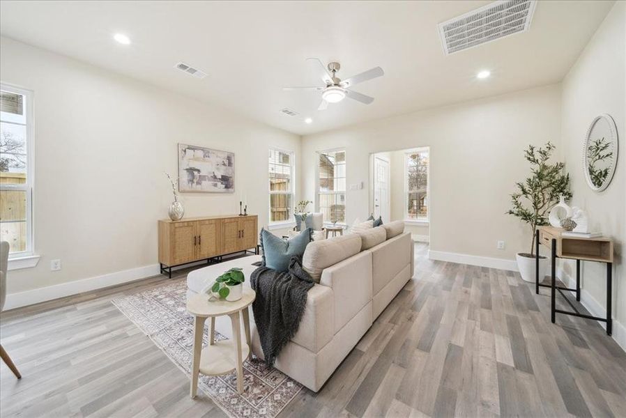 Living room with plenty of natural light, ceiling fan, and light wood-type flooring