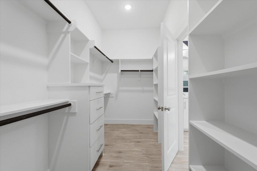 The walk-in closet is complete with floor-to-ceiling storage, built-in drawers, and plenty of shelving. The walk-in closet is complete with floor-to-ceiling storage, built-in drawers, and plenty of shelving.
