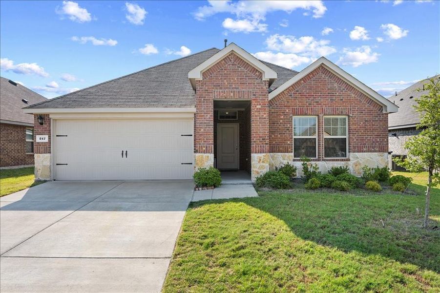 Single story home featuring brick siding, driveway, a shingled roof, and stone siding Single story home featuring brick siding, driveway, a shingled roof, and stone siding