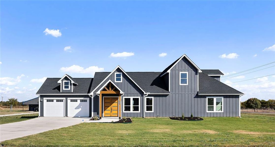 Modern farmhouse with a front yard and a garage