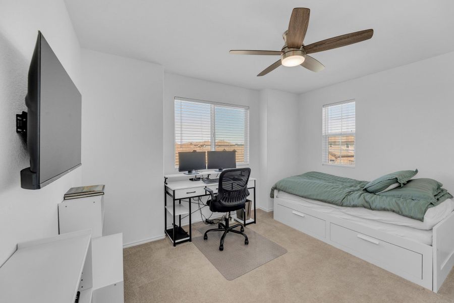 Bedroom featuring light colored carpet, baseboards, and ceiling fan