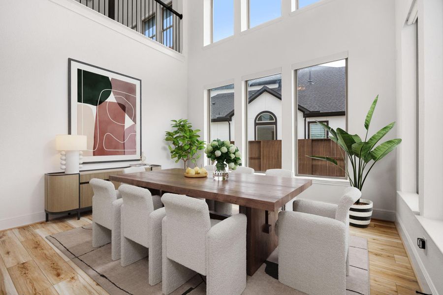 An open dining space highlighted by tall ceilings and abundant natural light.