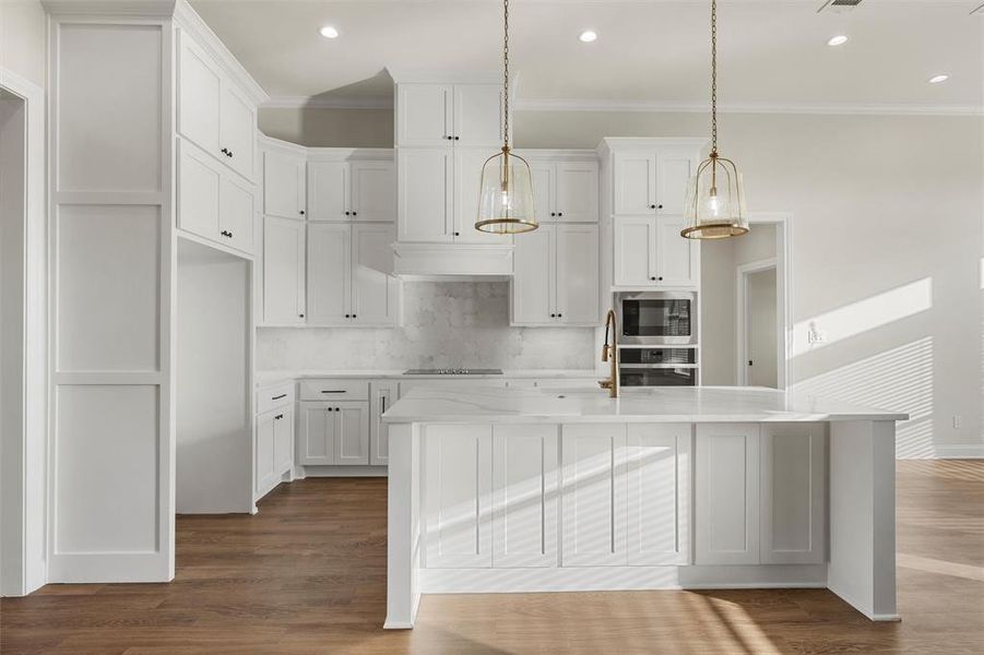Kitchen featuring white cabinets, tasteful backsplash, crown molding, dark wood-type flooring, and light stone counters Kitchen featuring white cabinets, tasteful backsplash, crown molding, dark wood-type flooring, and light stone counters