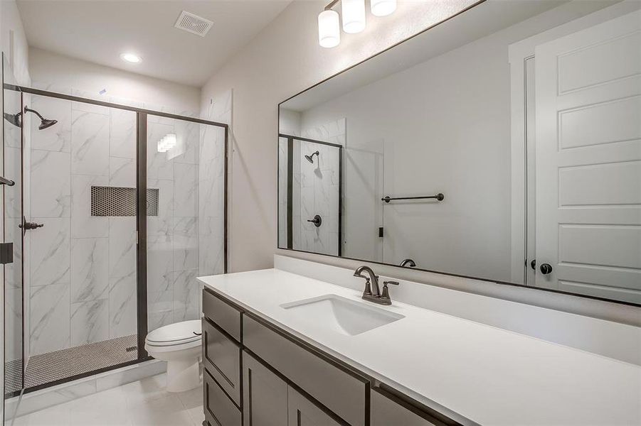 Full bath with vanity, visible vents, recessed lighting, toilet, and a marble finish shower Full bath with vanity, visible vents, recessed lighting, toilet, and a marble finish shower