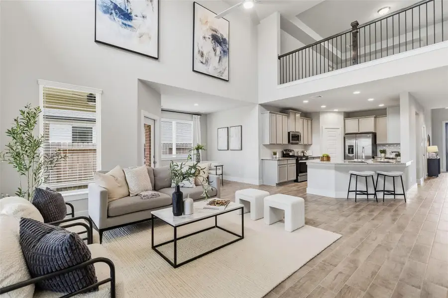Welcome to your stunning two-story living room showcases soaring ceilings, oversized windows, and an open-concept design that fills the space with light and creates a grand sense of scale.