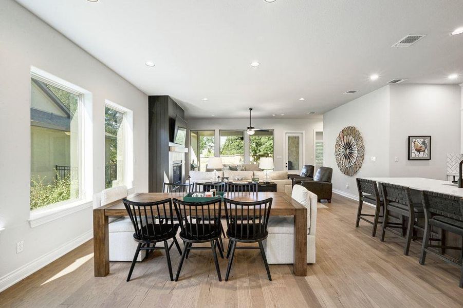 Dining area featuring recessed lighting, light wood finished floors, and a glass covered fireplace Dining area featuring recessed lighting, light wood finished floors, and a glass covered fireplace