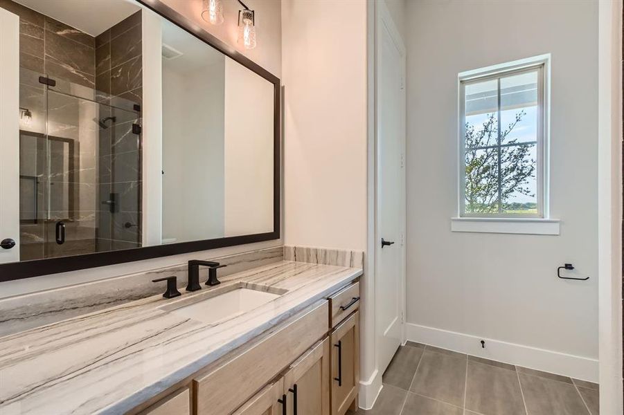 Full bath with vanity, a shower stall, and tile patterned flooring Full bath with vanity, a shower stall, and tile patterned flooring