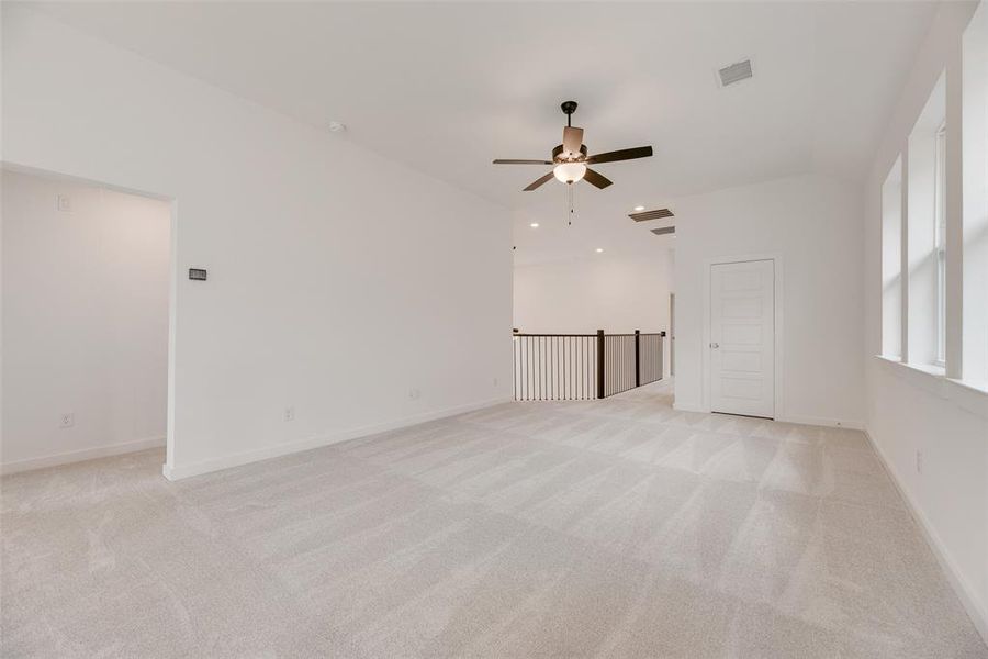 Unfurnished living room featuring light carpet and a ceiling fan Unfurnished living room featuring light carpet and a ceiling fan