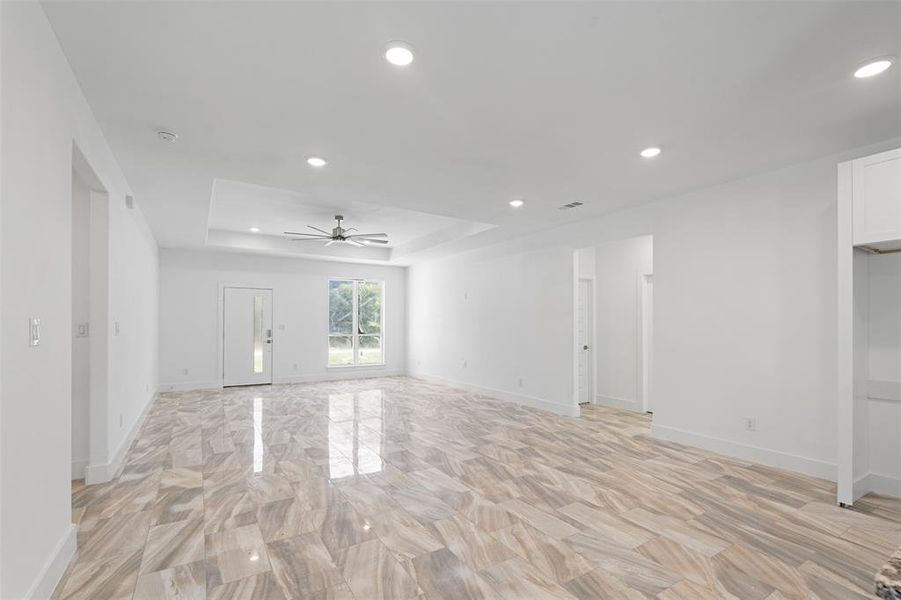 Spare room featuring a raised ceiling and ceiling fan