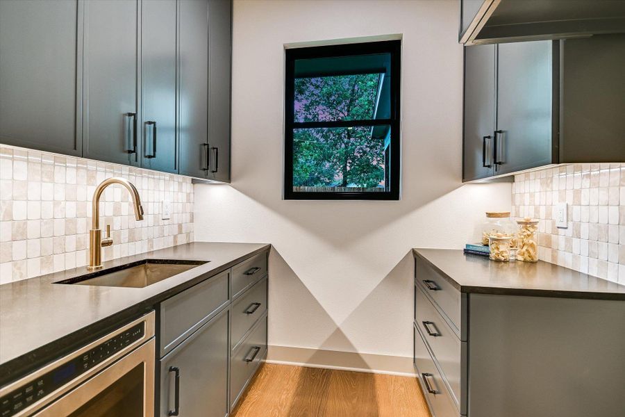 Unique & ultra-handy butler's pantry, equipped w/abundant cabinetry, a secondary sink, and a microwave - all illuminated by recessed ceiling and undercabinet lighting. Space for a 2nd refrigerator/freezer! Unique & ultra-handy butler's pantry, equipped w/abundant cabinetry, a secondary sink, and a microwave - all illuminated by recessed ceiling and undercabinet lighting. Space for a 2nd refrigerator/freezer!