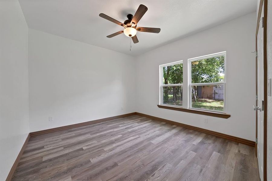 Empty room featuring light wood finished floors and a ceiling fan