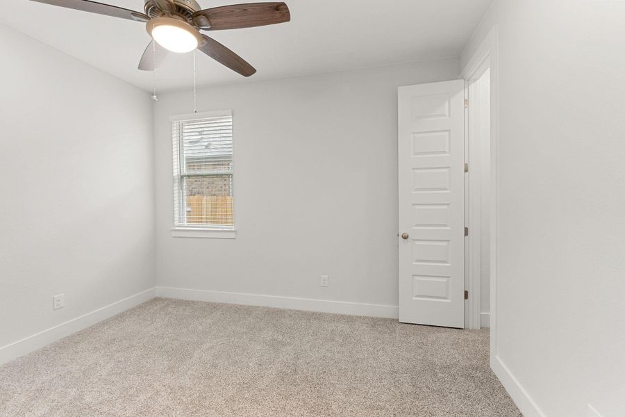 Unfurnished room with light colored carpet, baseboards, and ceiling fan Unfurnished room with light colored carpet, baseboards, and ceiling fan