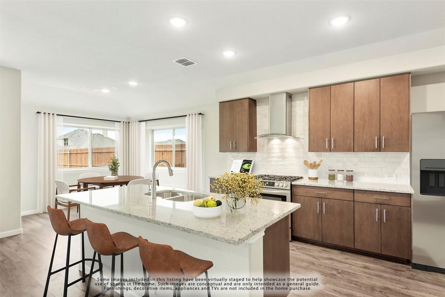 Kitchen with granite island, brown cabinets, subway tile backsplash, and stainless steel range with hood vent