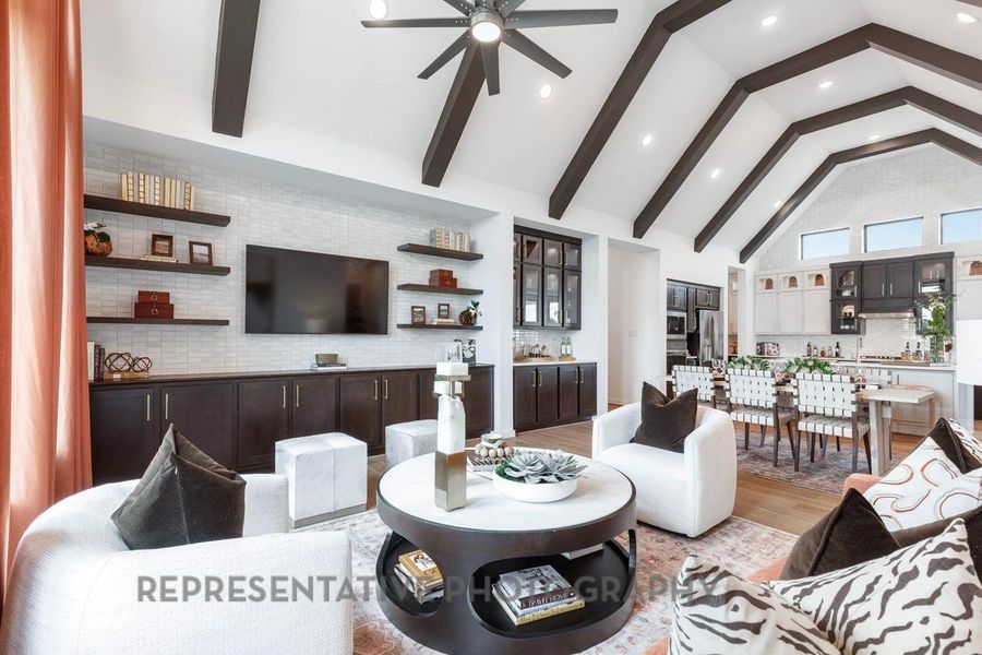 Living area featuring a ceiling fan, light wood-type flooring, high vaulted ceiling, beam ceiling, and recessed lighting