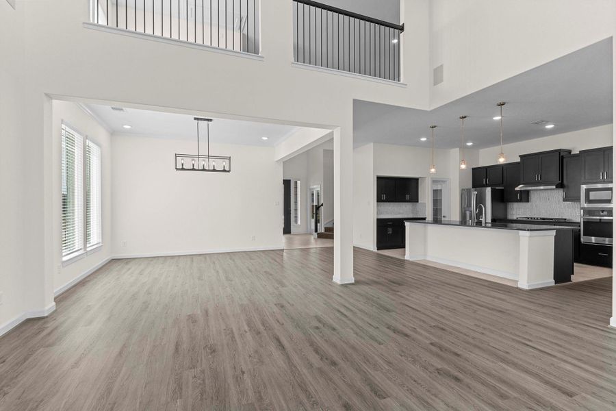 Open-concept view from the family room into the gourmet kitchen, highlighting soaring ceilings, natural light, and seamless flow for entertaining. Open-concept view from the family room into the gourmet kitchen, highlighting soaring ceilings, natural light, and seamless flow for entertaining.