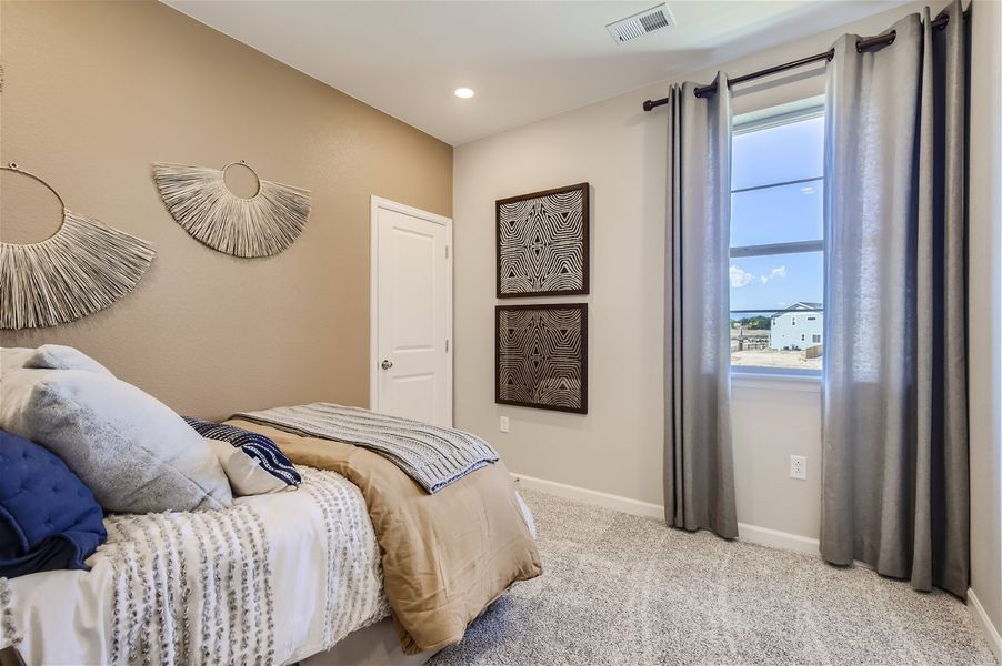 A bedroom with a large window. A bedroom with a large window.