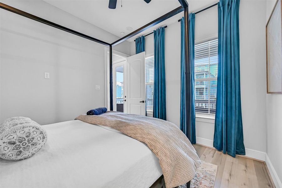 Floor to ceiling drapery and oversized windows give this bedroom a soft, relaxing atmosphere. The layout feels open while still offering privacy.