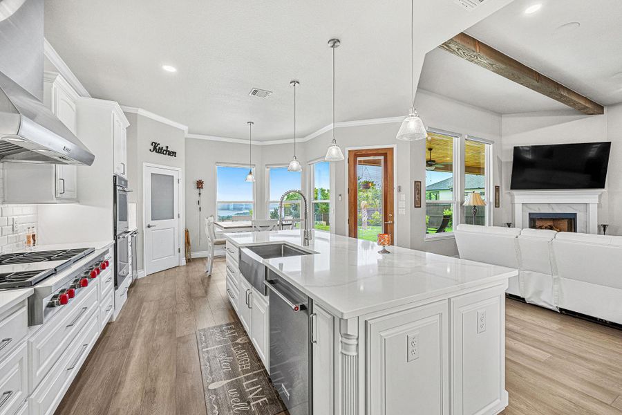 An open concept kitchen features a large island with a farmhouse sink and modern stainless steel appliances. An open concept kitchen features a large island with a farmhouse sink and modern stainless steel appliances.