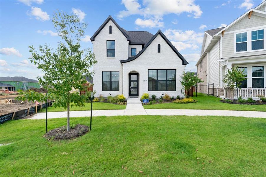 View of front of house with fence and a front lawn