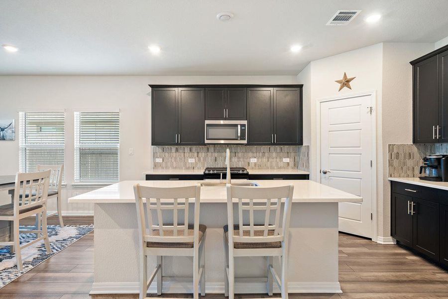 Contemporary kitchen highlighted by a large island with seating, quartz countertops, and ample cabinet space. Contemporary kitchen highlighted by a large island with seating, quartz countertops, and ample cabinet space.