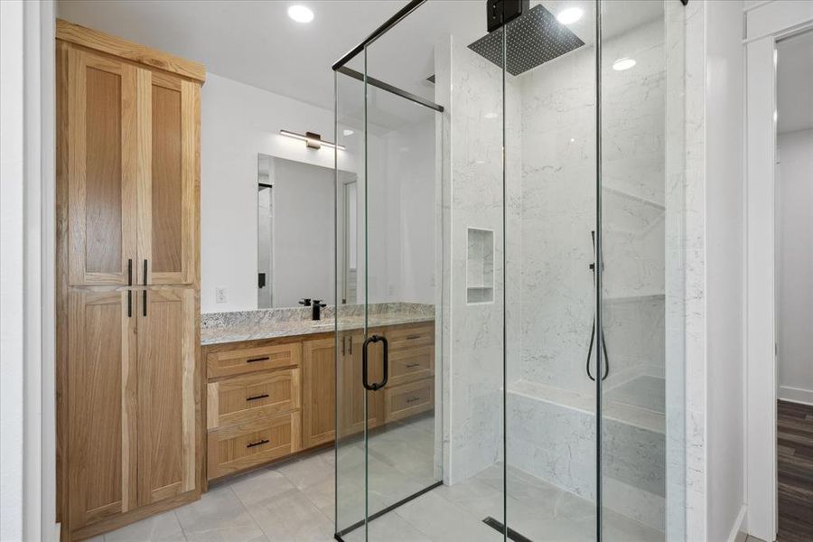 Bathroom featuring a marble finish shower, vanity, tile patterned flooring, and recessed lighting