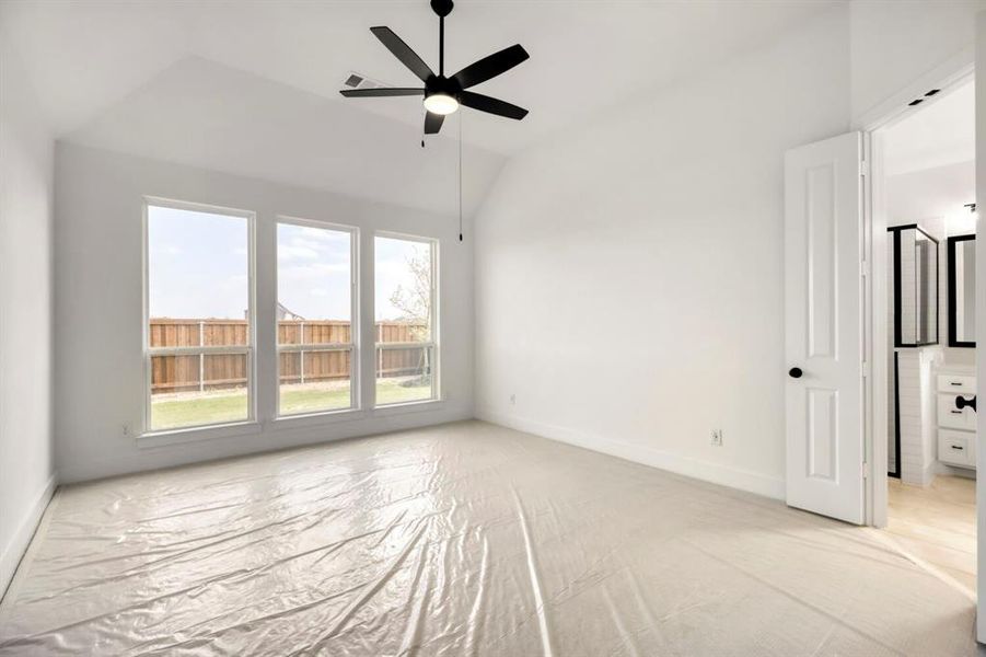 Unfurnished bedroom with lofted ceiling and ceiling fan