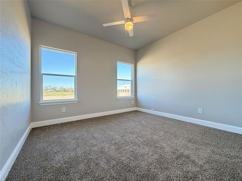 Spare room with dark colored carpet and ceiling fan
