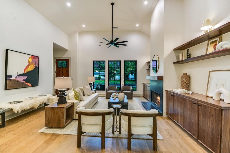 What an inviting living area with a high ceiling and a sleek modern fireplace - perfect for relaxation and entertaining! What an inviting living area with a high ceiling and a sleek modern fireplace - perfect for relaxation and entertaining!