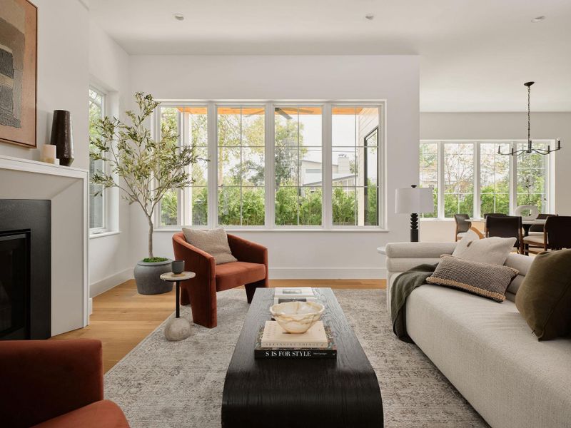 Living area featuring a glass covered fireplace, a chandelier, light wood-style flooring, plenty of natural light, and recessed lighting Living area featuring a glass covered fireplace, a chandelier, light wood-style flooring, plenty of natural light, and recessed lighting