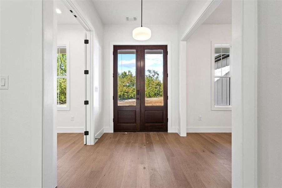 Entrance foyer with light wood finished floors and french doors Entrance foyer with light wood finished floors and french doors